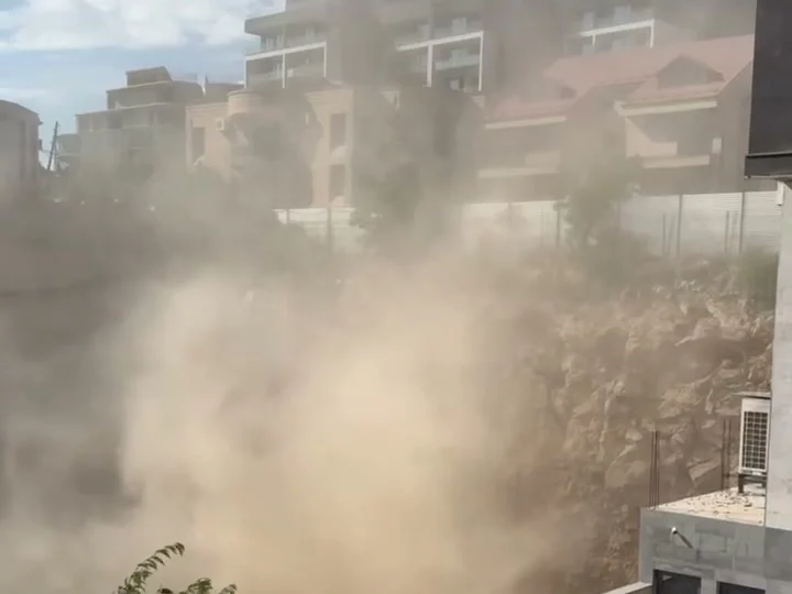 Плотное облако пыли поднимается из котлована к жилым домам